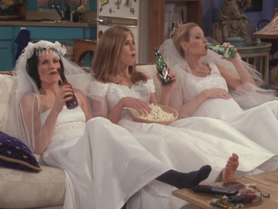 The girls cheer up Rachel by sitting wearing wedding dresses and drinking 